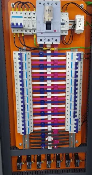 Interior de painel elétrico com disjuntores em trilho DIN e cabeamento identificado.